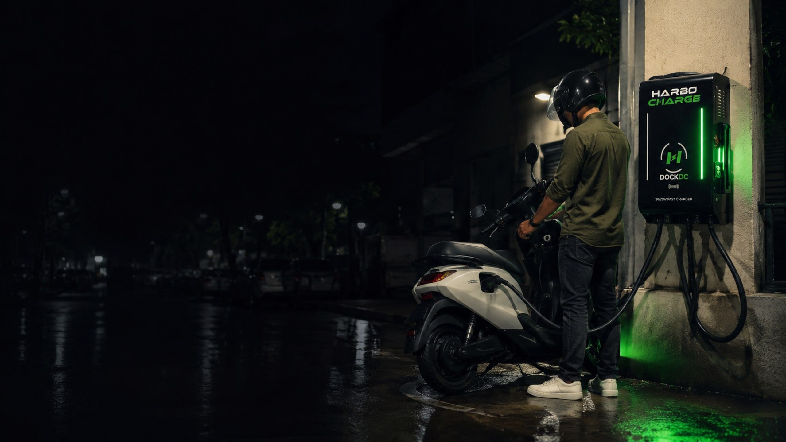 A rider charging an electric scooter at a HarboCharge dock at night